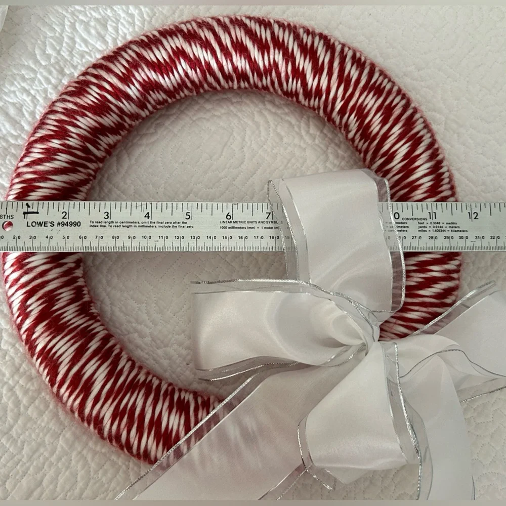 Red & white Candycane style Wreath. White bow accent. Approx 12”. Ready to hang.